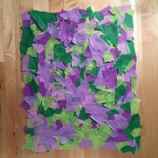 Colorful pieces of torn up tissue paper stuck to contact paper