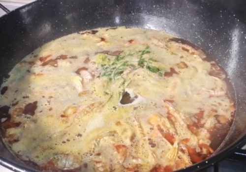 Una olla con los ingredientes para hacer un caldo de pescado antes de colar