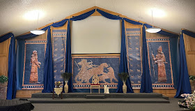 Backdrop of blue printed mesopotamian panels and blue fabric draping to make a Babylonian set in a church sanctuary