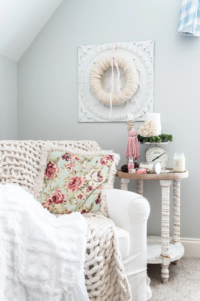 feminine corner with cozy chair, blankets and pillows, side table with vintage decor