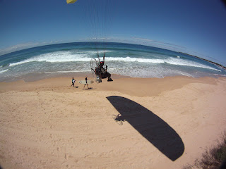 Low flying along the beach and surfers in the south of Sydney