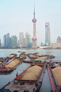 A traffic jam of barges against the skyline of Shanghai