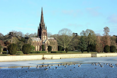 Photo of the chapel over a lake with geese swimming