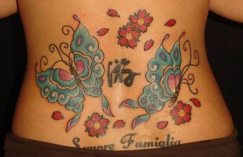 gun tattoos on waist. butterfly lower back tattoos.