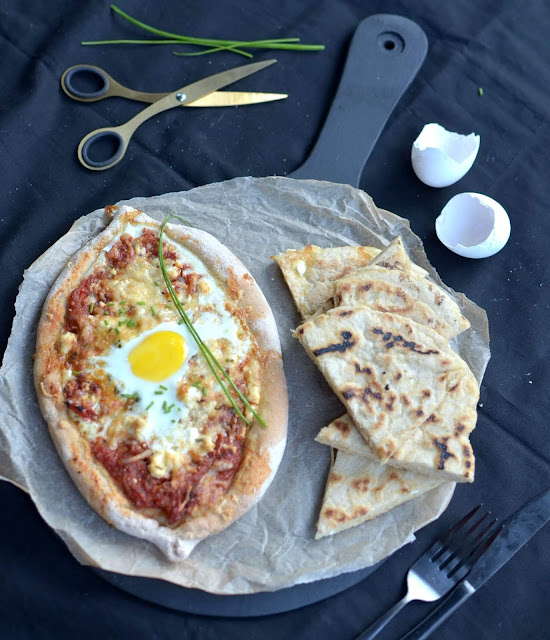 Khachapuri được cho là xuất hiện tại Gruzia từ thế kỷ XVI, khi những người lính La Mã đến vùng Biển Đen và mang theo công thức bánh mì nướng của họ. Khachapuri được coi như là họ hàng với pizza, lý do vì bột bánh rất giống và bánh cũng có phần nhân ngập phô mai như pizza. Bột bánh Khachapuri cũng là bột bánh mì tương tự pizza, gồm bột mì, nước, chút muối và men nở.