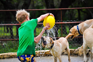 Ben holding up that big yellow ball and water is coming out of holes in it, Bob is trying to catch all of the water in his mouth