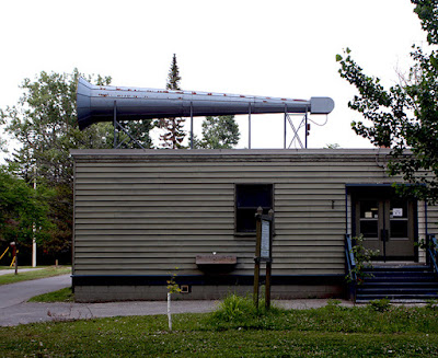 A long horn mounted on the roof of a non-descript building