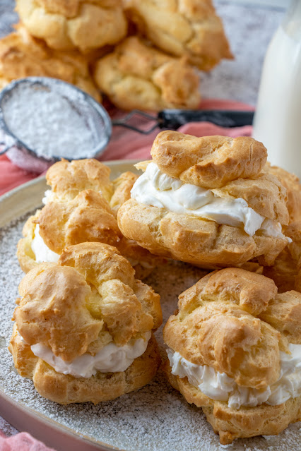 stack of cream puffs on a gray plate.