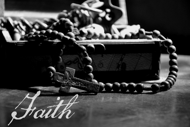 image of rosary beads in a box with the word faith written on it.