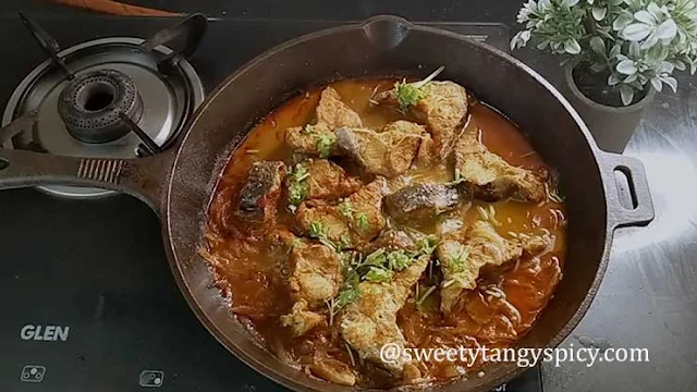 "Garnishing Fish Vindaloo with Fresh Coriander Leaves"