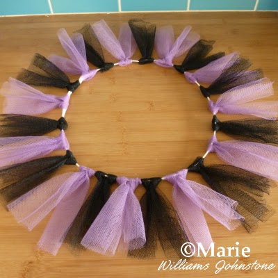Black and purple tulle strips tied to a wire wreath frame