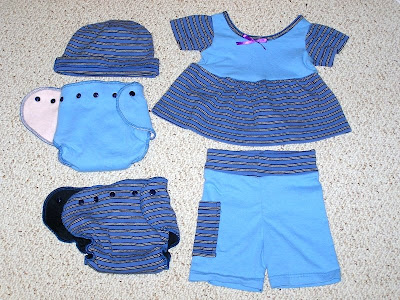 picture of 2 diapers with a matching dress, shorts, and a hat