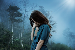 A girl standing in the forest with a book in hand close to her heart- Sad Girl DP 1