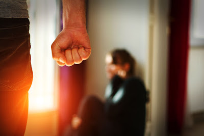 abusive man standing over his wife