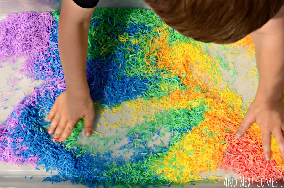 Playing with rainbow dyed shredded coconut - colorful, scented sensory play from And Next Comes L