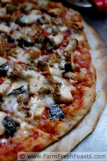 close shot of grilled eggplant and chicken parm pizza