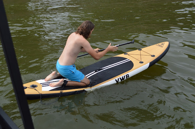 Andy kneeling on the paddleboard.