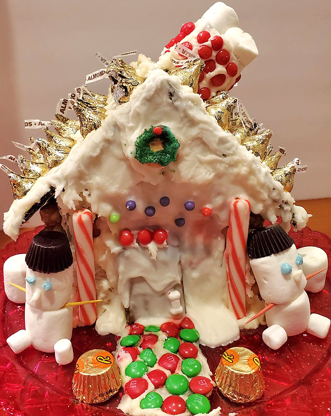 this is a cardboard container turned into a Christmas Candy house with all marshmallows , and colorful candies and frosting stuck to the sides