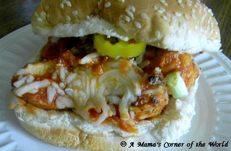 Chicken Parmesan sandwich with chicken, mozzarella cheese, banana pepper rings and onions on a sesame seed bun 