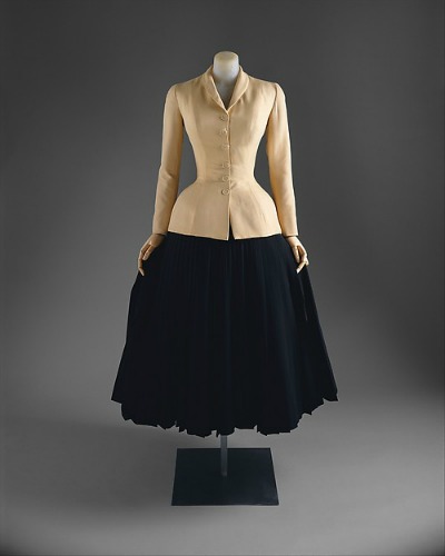 Beige form fitting jacket with black full skirt in Dior New Look style on display on dress form