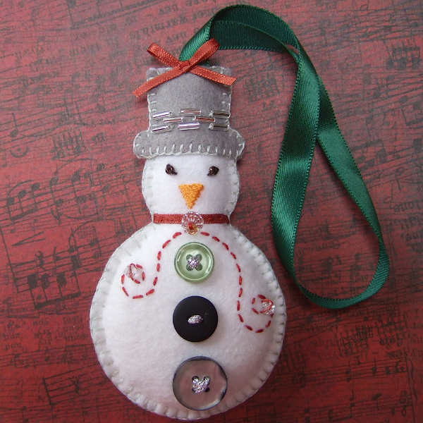 White felt embroidered snowman with bead and button decorations tree