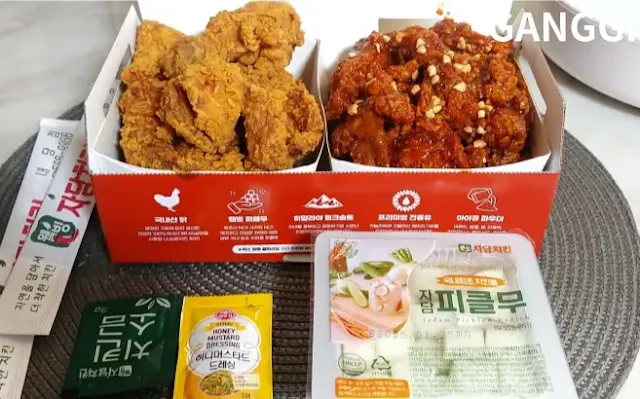 자담치킨-후라이드-양념-반반-치킨과-소스-치킨무-젓가락이-놓여진-사진