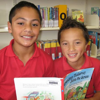 two young boys holding a book
