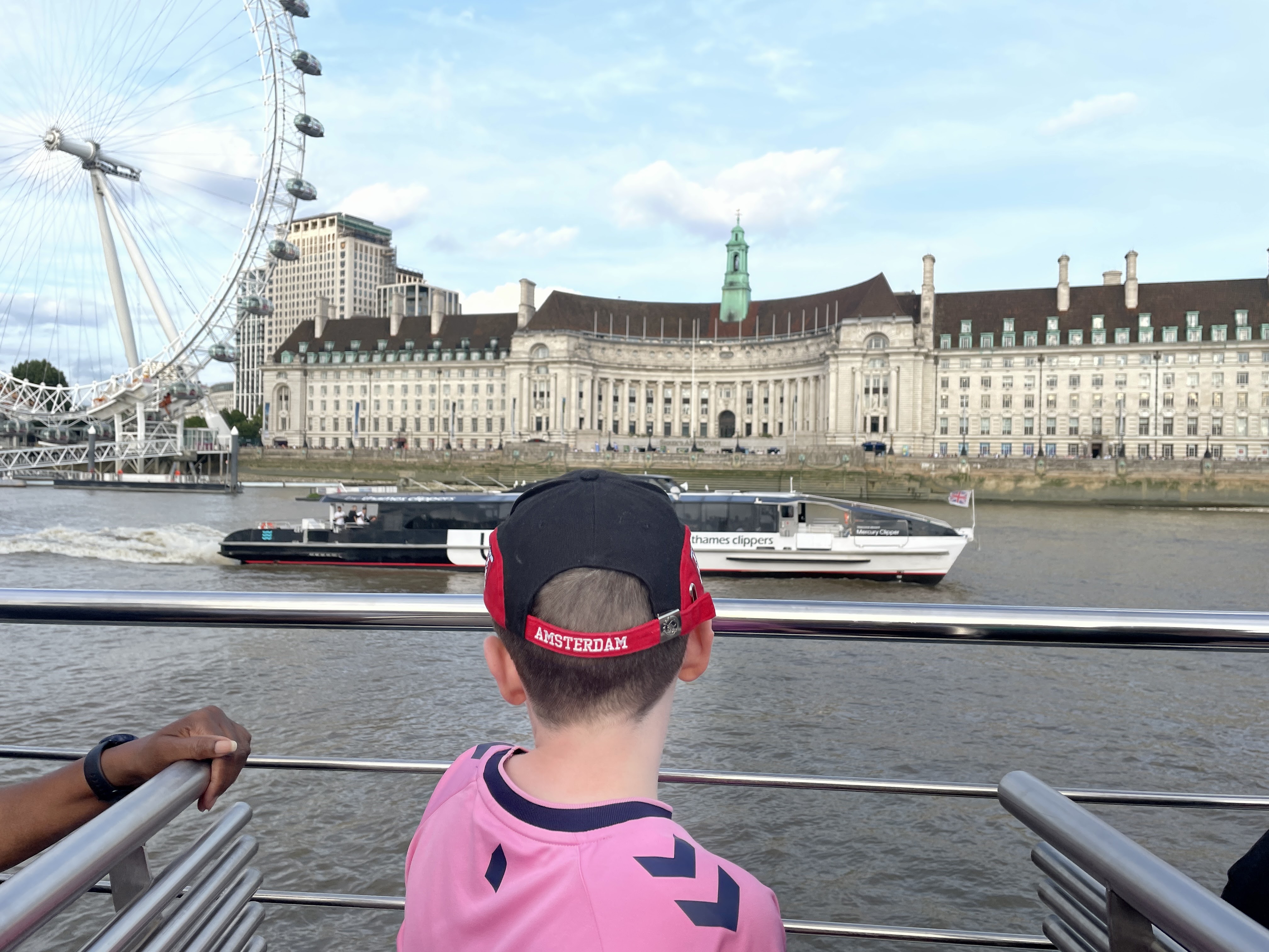 boy looking at the london eye from a boat