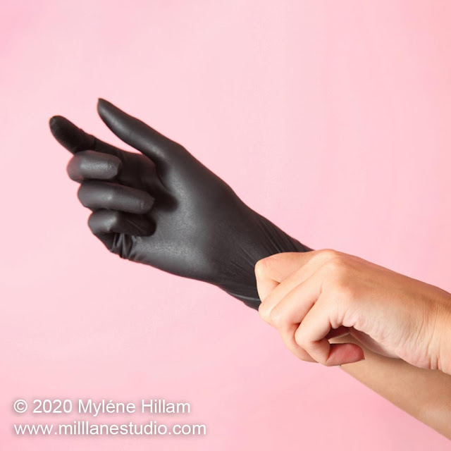 Putting on a pair of black nitrile gloves