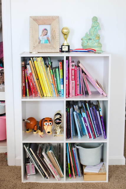 Books sorted by the rainbow in a shared girls' room