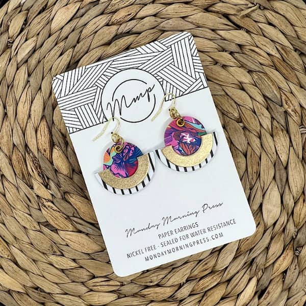 colorful pair of circular, geometric earrings made of floral and striped black and white papers
