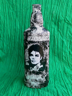 This recyled bottle has image of Michael Jackson decoupaged on it and the textured created with gesso and acrylic color. 