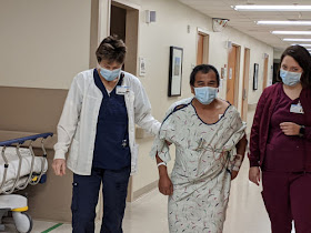 man in hopital gown walking