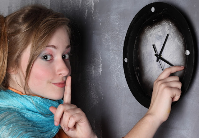 Jeune femme, réglant une horloge.