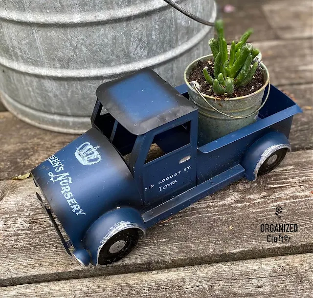 Photo of a blue truck with decor transfers on the deck with a succulent plant in the truck bed