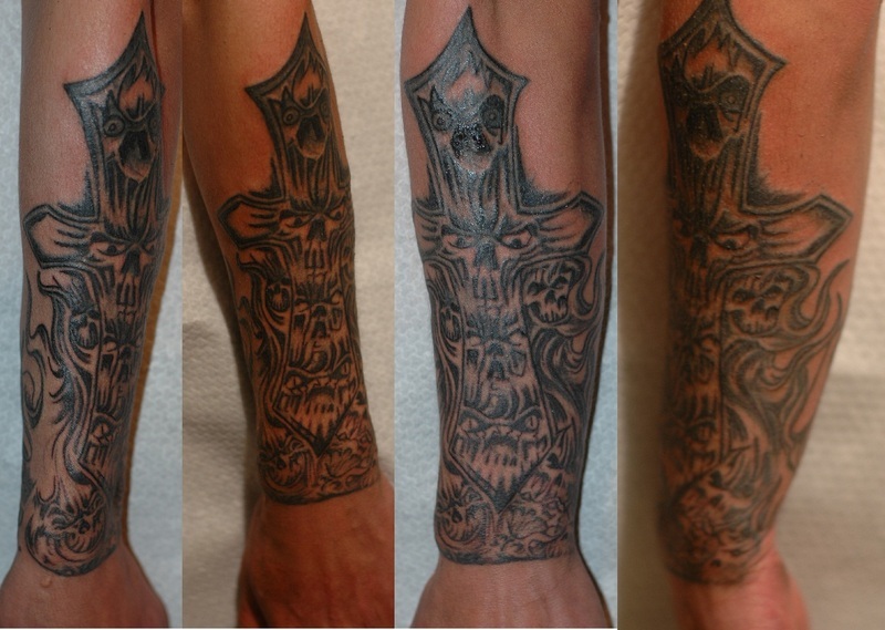 cross tattoos for men on forearm. Cross with skull faces.