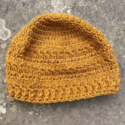 Flat lay of a crocheted hat on a lichen covered piece of slab