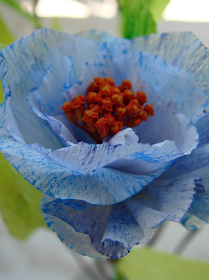 fiori di carta crespa e fiori secchi blu, arancio e foglie per un matrimonio al mare