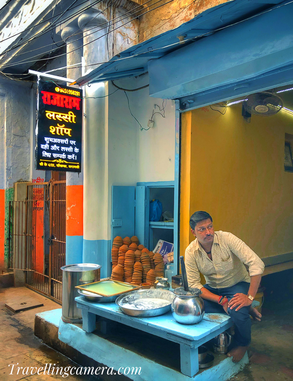 Varanasi is a city known for its delicious lassi, and there are many famous lassi shops in the area that are popular among locals and tourists alike. Here are a few famous lassi shops in Varanasi:  Blue Lassi Shop: This is a popular lassi shop located in the old city of Varanasi, near the Kashi Vishwanath Temple. It is known for its authentic and delicious lassi made using traditional methods and ingredients.  Bhagat Ji Lassi Wale: This is another popular lassi shop in Varanasi, known for its thick and creamy lassi. It is located in the heart of the city, and it is a favorite among locals and tourists.  Kashi Chat Bhandar: This is a famous street-side lassi shop that is known for its unique and delicious flavors. It is located in the old city, near the Kashi Vishwanath Temple.  Sita Ram Dewan Chand: This is another popular lassi shop in Varanasi, known for its traditional and authentic lassi. It is located near the Assi Ghat.  The Lassi Shop: This is a modern lassi shop located in the heart of the city, known for its unique and delicious flavors. It is a great place to try different types of lassi, and it is also famous among the foreigners visiting Varanasi.  It's worth mentioning that these are a few famous lassi shops out of many others in Varanasi. Some other popular shops include Singh Lassi Bhandar, Kala Lassi Wala, and Raju Lassi Wala. You can also find small street vendors selling lassi, they might not be as famous, but their lassi is also worth trying. You can ask locals for recommendations or simply follow your nose to find the best lassi in Varanasi.