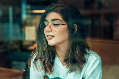 a beautiful girl wearing glasses and smiling