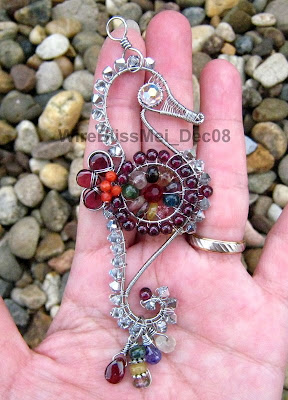 holding the Wire Wrapped Seahorse Pendant with multiple colorful gemstones