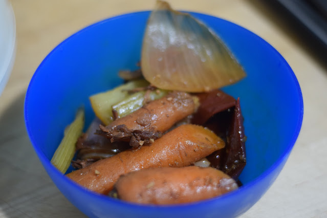 The carrots, celery, and onion being removed from the crockpot.
