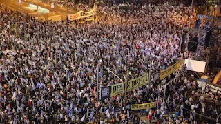 Israel : For the 21st week, Tens of thousands of Israelis demonstrate against the "Judicial Reform" plan  After Israeli Prime Minister Benjamin Netanyahu revealed his intention to introduce "judicial reform" bills again, tens of thousands of Israelis took to the streets to demonstrate against the plan on Saturday.  Tens of thousands of Israelis demonstrated on Saturday against the plan to "reform the judiciary", which the government of Prime Minister Benjamin Netanyahu intends to implement, for the 21st week in a row.  Yedioth Ahronoth (private) newspaper reported on its website that 80,000 people demonstrated on Kaplan Street in downtown Tel Aviv against the plan to reform the judiciary.  The newspaper indicated that thousands of others demonstrated in the cities of Raanana and Haifa (north), Kfar Saba (center), and other places in the country.  The newspaper said that the police closed a number of main streets near the demonstration sites throughout Israel.  As of 20:05 (GMT), the Israeli authorities have not issued any comment on the opposition demonstrations.  And last Wednesday, Netanyahu announced that the "judicial reform" bills would come back again after the Knesset approved Israel's budget.  The (official) broadcaster quoted Netanyahu as saying, "Changes in the judiciary will certainly return to the fore. We are in the midst of dealing with them, and we are trying to reach understandings with the opposition regarding them."  Netanyahu announced more than two months ago the suspension of "judicial reform" bills to allow room for reaching understandings with the opposition.  Since that time, talks have been taking place between the opposition and the government coalition under the auspices of Israeli President Isaac Herzog, without any signs of agreement appearing on the horizon.  The opposition says that these projects "aim at weakening the judiciary, especially the Israeli Supreme Court, and turning Israel into a dictatorship."  For more than 21 weeks, the opposition has been organizing unprecedented weekly protests across Israel to demand the suspension of "judicial reform" bills.