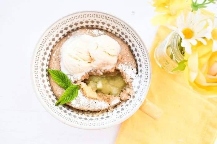 Overhead shot of microwave apple sponge pudding, with a spoonful removed so you can see the apple filling