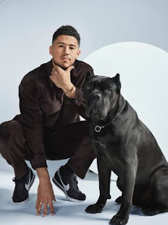 Devin Booker posing for the picture with the dog