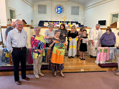 a group displays the dresses they have made