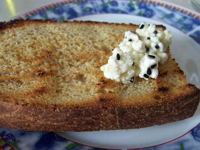 Kızarmış nohut mayalı ekmek dilimi üzerinde karacaotlu peynir
