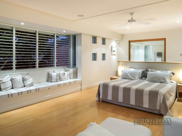 Photo of large modern bedroom with sitting area by the window 