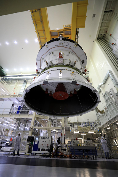 A low-angle view of the Orion capsule with the launch adapter attached to it...with the service module's main engine visible at the bottom of the spacecraft.