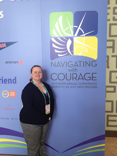 Woman standing in front of logo for NASPA 2015